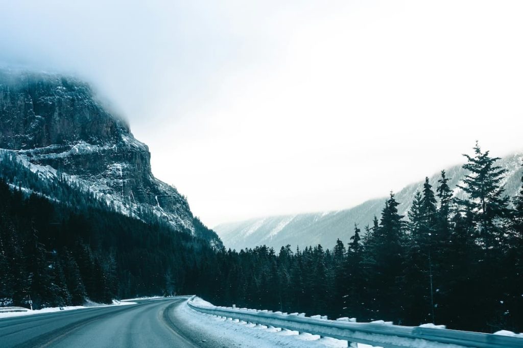 Scenic drive to Mount Revelstoke National Park with snow-capped mountain beside the highway