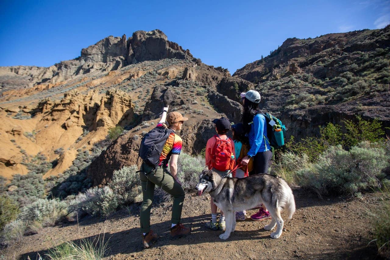 Mom and daughter with a dog on a guided mountain tour in Kamloops